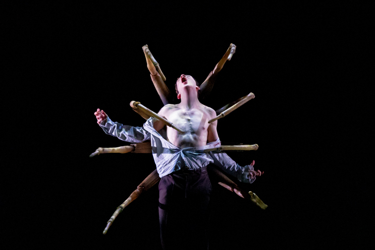 A shirtless teen with spider legs coming out of him